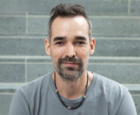 headshot of man with short hair, wearing tshirt, smiling 